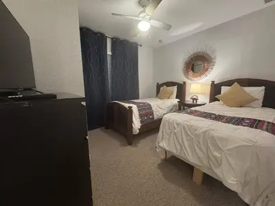 a bedroom with two beds and a flat screen tv at 4 Bedroom 3 Bathroom Villas At SevenDwarfs 22-108 in Kissimmee