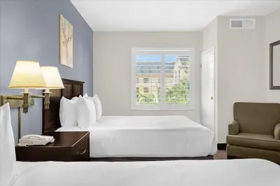 a hotel room with two beds and a chair at Studio Apartment w Pool & Hot Tub - Near Universal Studio in Orlando