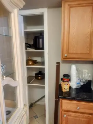 a kitchen with an empty pantry with a refrigerator at A peaceful living vibe in Orlando