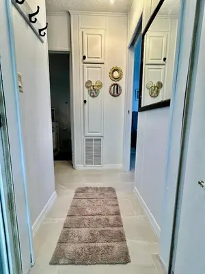 a hallway with a white door and a rug at Your home away from home! Entire cottage- Disney in Kissimmee