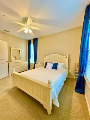 a bedroom with a large bed with blue curtains at Chic 1-Bedroom Apt in Lake Nona in Orlando