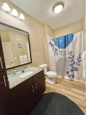 a bathroom with a sink and a toilet and a shower curtain at Chic 1-Bedroom Apt in Lake Nona in Orlando