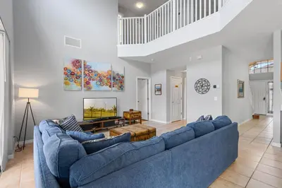 a living room with a large blue couch at La Isla Retreat - amazing 6 bedroom pool house near Disney Parks in Kissimmee