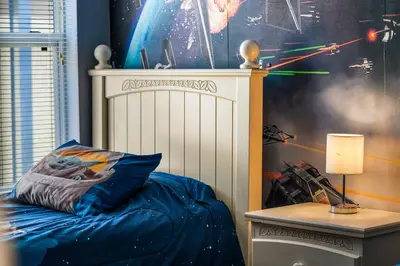 a bedroom with a bed with a star wars wall at La Isla Retreat - amazing 6 bedroom pool house near Disney Parks in Kissimmee
