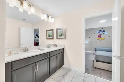 a bathroom with a sink and a mirror at Lakefront Luxury Retreat Private Pool & Movie Theater 367 in Kissimmee