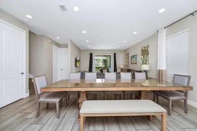 a dining room with a wooden table and chairs at Spacious Home With Private Pool, Themed And Game Room Near Disney With Waterpark & Resort Access - 341Pn in Kissimmee