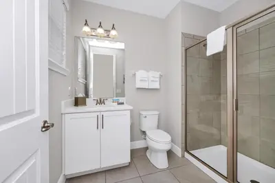 a white bathroom with a toilet and a shower at Marvelous Home With Private Pool And Waterpark & Resort Access Near Disney At Encore Resorts Reunion - 7464Mr in Kissimmee