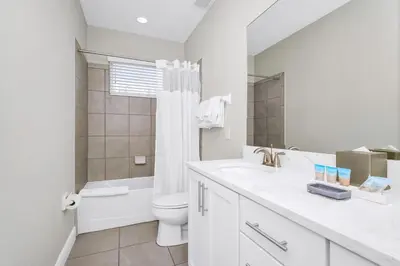 a white bathroom with a toilet and a sink at Marvelous Home With Private Pool And Waterpark & Resort Access Near Disney At Encore Resorts Reunion - 7464Mr in Kissimmee