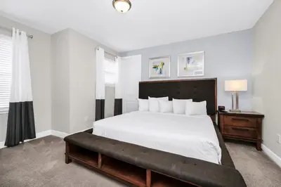 a bedroom with a large white bed with a bench at Marvelous Home With Private Pool And Waterpark & Resort Access Near Disney At Encore Resorts Reunion - 7464Mr in Kissimmee