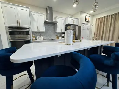 a kitchen with a white counter and blue chairs at Bloomslake Resort in Kissimmee
