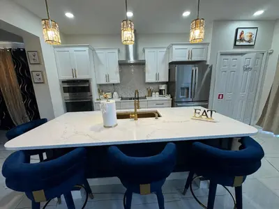 a kitchen with a kitchen island with blue chairs at Bloomslake Resort in Kissimmee