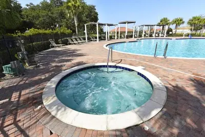 a hot tub in a patio next to a swimming pool at Modern Guesthouse near MCO in Kissimmee