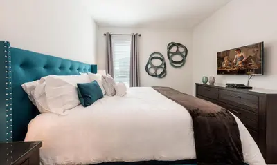 a bedroom with a large bed with a blue headboard at Luxury Private Villa with Large Pool on Encore Resort at Reunion Orlando Villa 4433 in Orlando