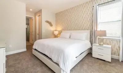 a white bedroom with a bed and a window at Rent the Perfect 8 Bedroom Villa on Encore Resort at Reunion Orlando Villa 4474 in Orlando