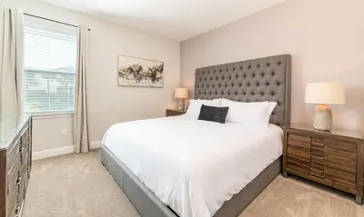 a bedroom with a large bed and a window at Rent the Perfect 8 Bedroom Villa on Encore Resort at Reunion Orlando Villa 4474 in Orlando