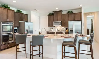 a kitchen with a large island with bar stools at 5 Star Villa on Orlando’s most Exclusive Encore Resort at Reunion Orlando Villa 4377 in Orlando