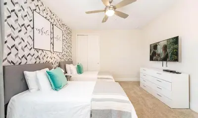 a bedroom with two beds and a ceiling fan at 5 Star Villa on Orlando’s most Exclusive Encore Resort at Reunion Orlando Villa 4507 in Orlando