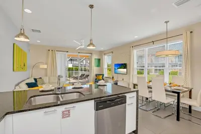 a kitchen and living room with a table and chairs at Modern Townhome with 3 Bedrooms 5506 in Orlando