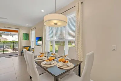 a dining room with a table and white chairs at Modern Townhome with 3 Bedrooms 5506 in Orlando