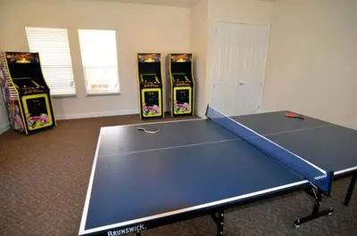 a ping pong table in a room with four video games at Modern Townhome with 3 Bedrooms 5506 in Orlando