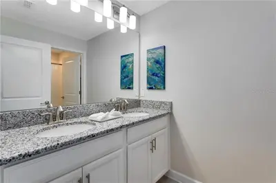 a bathroom with two sinks and a large mirror at Luxury Townhome on Storey Lake Resort Orlando Townhome 5523 in Kissimmee