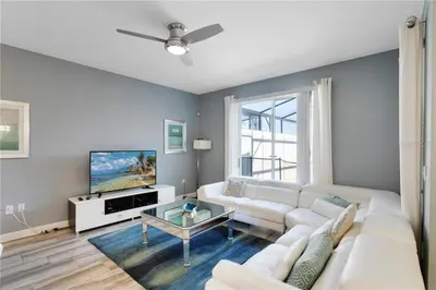 a living room with a white couch and a tv at Luxury Townhome on Storey Lake Resort Orlando Townhome 5523 in Kissimmee