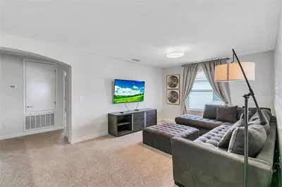 a living room with a couch and a flat screen tv at You Will Love this 5 Star Villa located on Storey Lake Resort Orlando villa 5492 in Kissimmee
