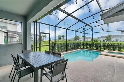 a dining room with a table and a swimming pool at You Will Love this 5 Star Villa located on Storey Lake Resort Orlando villa 5492 in Kissimmee