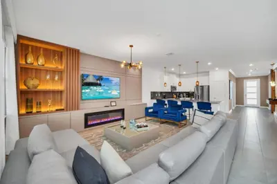 a living room with a large couch and a kitchen at Modern 9 Bedroom Oasis for Large Groups 6272 in Kissimmee