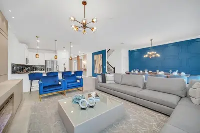 a living room with a gray couch and blue chairs at Modern 9 Bedroom Oasis for Large Groups 6272 in Kissimmee