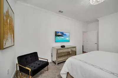 a bedroom with a bed and a chair at Modern 9 Bedroom Oasis for Large Groups 6272 in Kissimmee