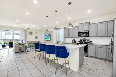 an open kitchen with blue bar stools in a room at Elegant Villa for Large Groups 6281 in Kissimmee
