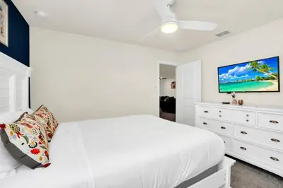 a white bedroom with a white bed and a dresser at Elegant Villa for Large Groups 6281 in Kissimmee