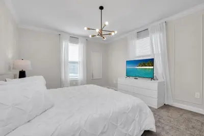 a white bedroom with a bed and a flat screen tv at Ultimate 5 Bedroom Villa Escape 6314 in Kissimmee