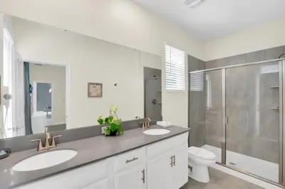 a bathroom with two sinks and a shower and a toilet at Escape to a 5 Bedroom Villa in Paradise 6316 in Kissimmee