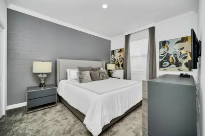 a white bedroom with a bed and two night stands at Family-Friendly Villa with 9 Bedrooms 6317 in Kissimmee