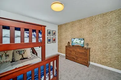 a bedroom with a crib and a tv in a room at Cozy 4 Bedroom Urban Oasis 6326 in Kissimmee