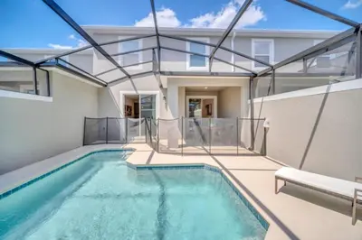 a swimming pool in a house with glass walls at Cozy 4 Bedroom Urban Oasis 6326 in Kissimmee