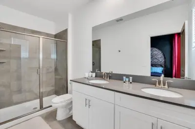 a bathroom with two sinks and a shower and a toilet at Private Oasis: 6 Bedroom Villa Retreat 6327 in Kissimmee