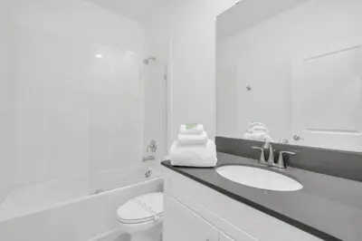 a white bathroom with a toilet and a sink at Elegant Villa Retreat with Private Pool 6328 in Kissimmee