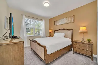a bedroom with a bed and a flat screen tv at Modern Villa with Game Room Theater 6334 in Kissimmee
