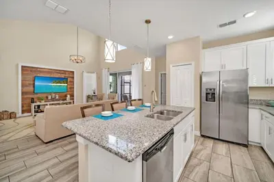 a kitchen with a counter top and a living room at Modern Villa with Game Room Theater 6334 in Kissimmee