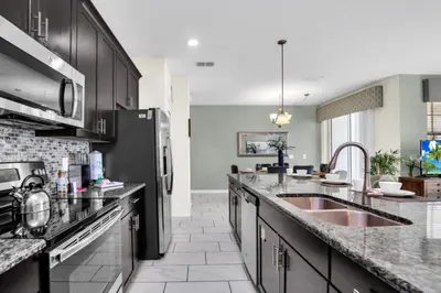 a kitchen with a sink and a refrigerator at Modern 4 Bedroom Villa near Beach Shopping 6335 in Kissimmee