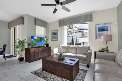 a living room with a couch and a tv at Modern 4 Bedroom Villa near Beach Shopping 6335 in Kissimmee