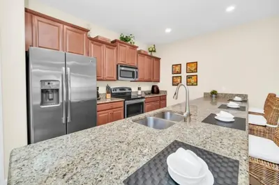a kitchen with stainless steel appliances and wooden cabinets at Tranquil Villa Retreat with Mountain Views 6338 in Kissimmee