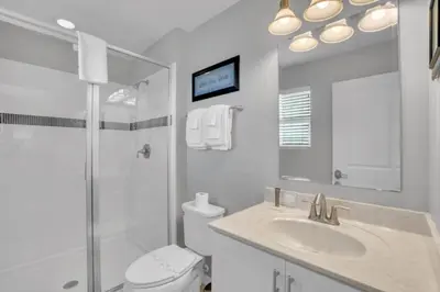 a bathroom with a shower and a toilet and a sink at Cozy 4BR Cottage with Fireplace 6379 in Kissimmee