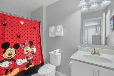 a bathroom with a mickey mouse shower curtain at Cozy 4BR Cottage with Fireplace 6379 in Kissimmee