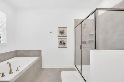a white bathroom with a tub and a shower at Spacious Villa Retreat with 9 Bedrooms 6381 in Kissimmee
