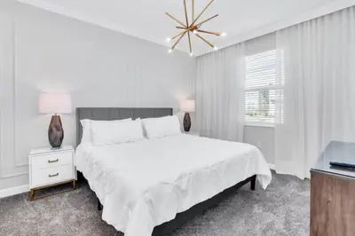 a white bedroom with a large bed and a window at Spacious Villa Retreat with 9 Bedrooms 6381 in Kissimmee