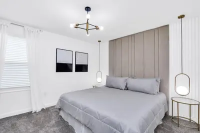a white bedroom with a large bed and two lamps at Spacious Villa Retreat with 9 Bedrooms 6381 in Kissimmee